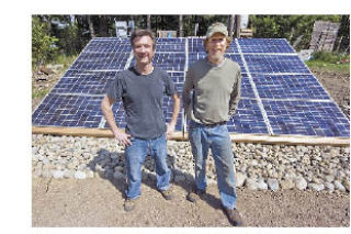 (from left) Doug Poole and Jeff Dyer stand in front of one of their recently installed solar panels on Lopez Island.