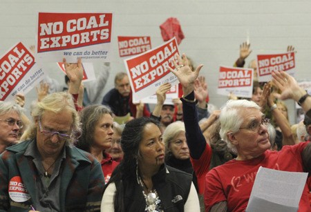 Audience members at the hearing voicing their opposition of the coal terminal.