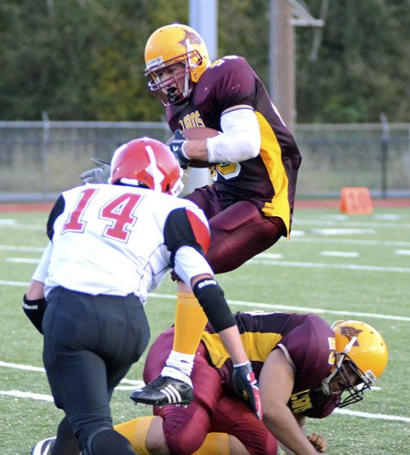 Tommy Kramer hurdles over blocker Daniel Jenison on one of several successful runs.  Lopez fell to Neah Bay in the District Playoff 60-20.