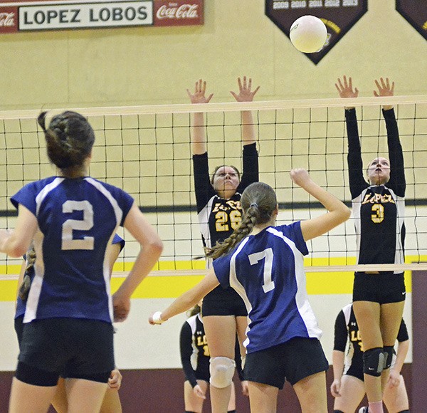 Shelby Prewitt (26) and Anah Kate Drahn (3) block a spike against Providence in the Lobos’ crucial 3-1 victory at home. 