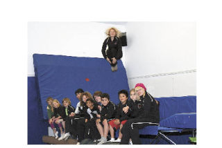 Anne Burton jumps on the trampoline above her trampoline students.