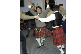 Left: Dance instructor Bill Paterson leading the men in a Scottish fling. Above: Dina Paterson showing off the fine beef pie.