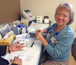 Nurse and diabetes educator Joann Mayo prepares to test the blood-glucose level of a participant in a state-funded free diabetes class