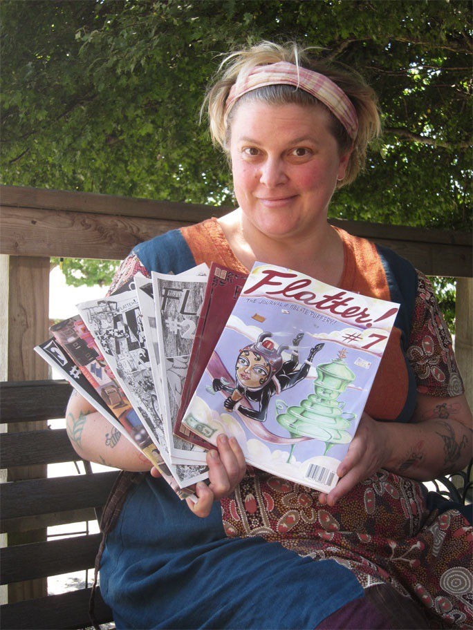 Jaina Bee Davis holding samples of the zines she’s produced over the years.