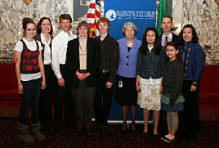 Washington State Librarian Jan Walsh (fifth from right) stands with the families of the three Letters About Literature champions. The Level I champion is Laura Claypool (fourth from right) and the Level II champion is Austin Horjus (fifth from left). The Level III champ