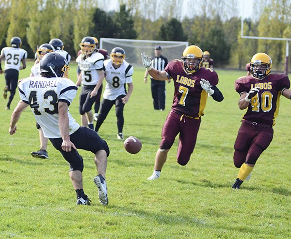 Toni Ahonen (7) and Vinny Kramer (40) pressure a Clallam Bay punter in the Lobos’ 56-0 victory at home. 