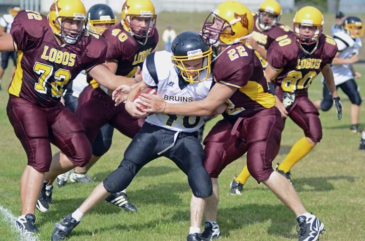 Derek Buffum (22) wraps up a Bruin runner while Mike Hobi (72)