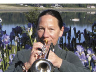 Ginni Keith plays her trumpet outside her practice space on Lopez Island.