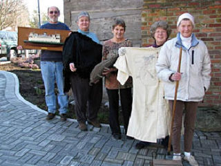 Photo caption: Volunteers line up with their treasures for the April 11 Antiques Evaluation Fair. Left to right