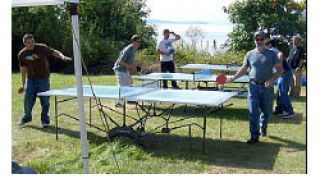 Ping-pong players enjoying a sunny day of table tennis at West Beach Resort.