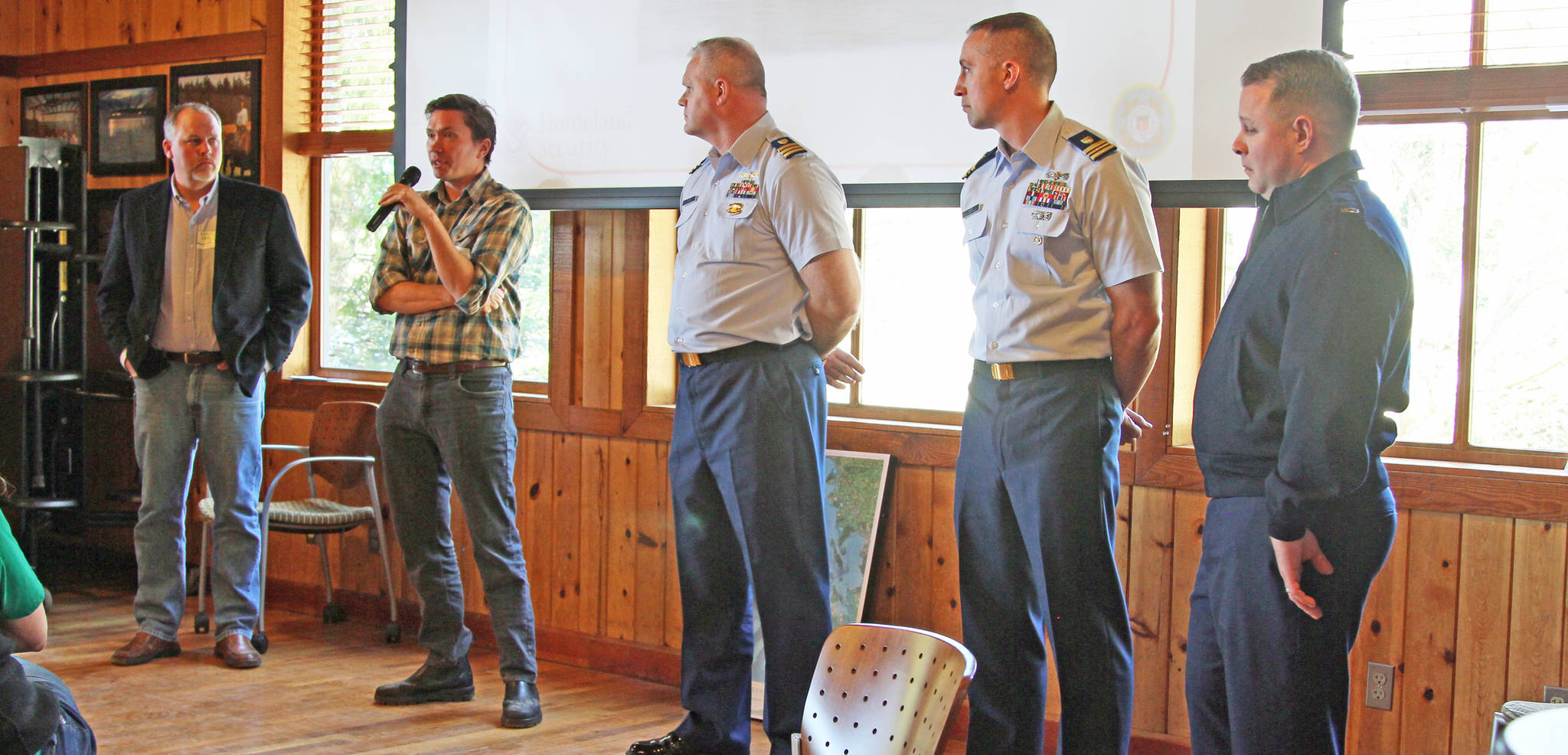 Ken Carrasco photo                                Response personnel from the Washington Department of Ecology and the U.S. Coast Guard listen as Cowan describes local government cleanup activities in case of an oil spill.