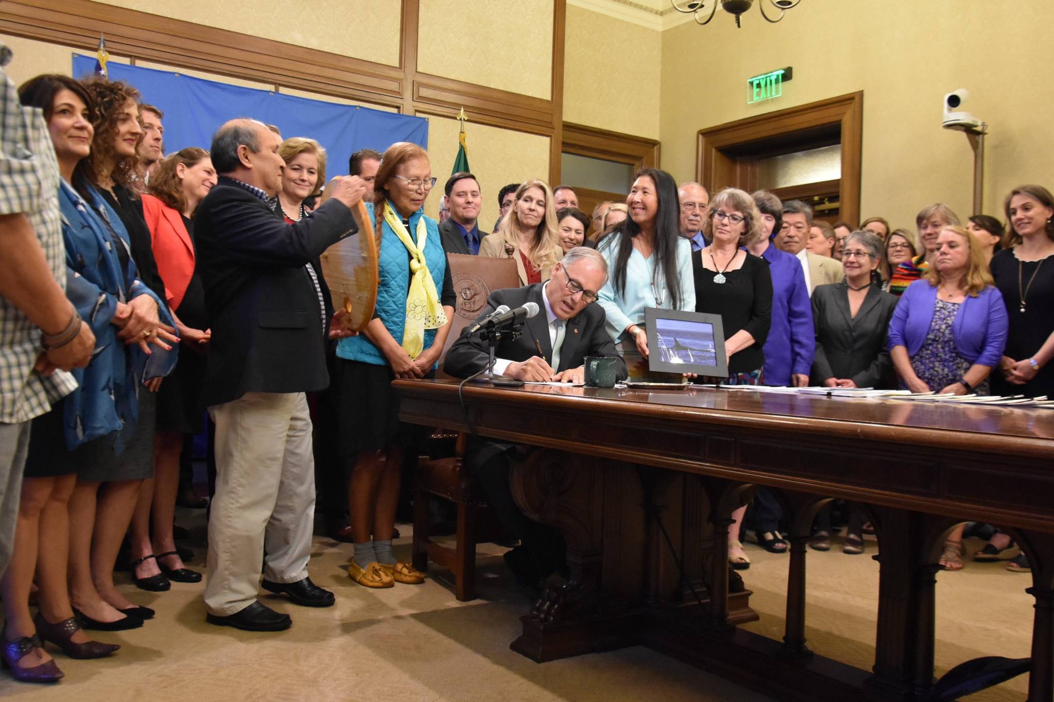 Gov. Jay Inslee signs one of five crucial orca recovery bills on Wednesday that protect the safety and livelihood of the Southern resident orca. (Office of the Governor photo)