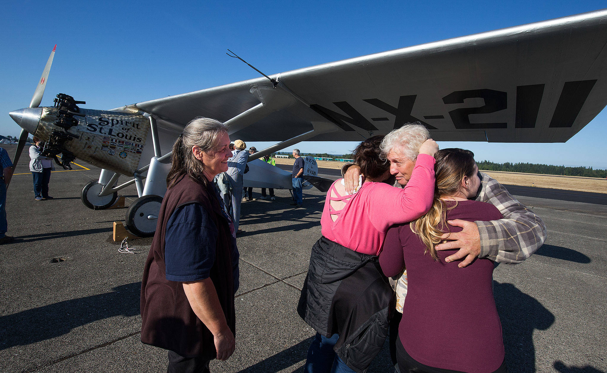 Andy Bronson/contributed photo                                As his wife, Heather, looks on, John Norman gets a hug from his daughter Amber Nelson and granddaughter Ashlee Nelson (right) after his replica of the Spirit of St. Louis flew for the first time from Arlington Municipal Airport on July 28.