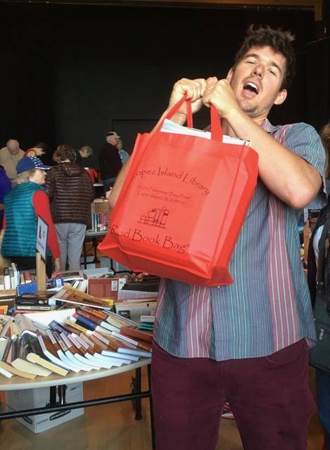 Contributed photo                                Charlie McGready hoists a full Red Bag in support of the Lopez Library Book Sale.