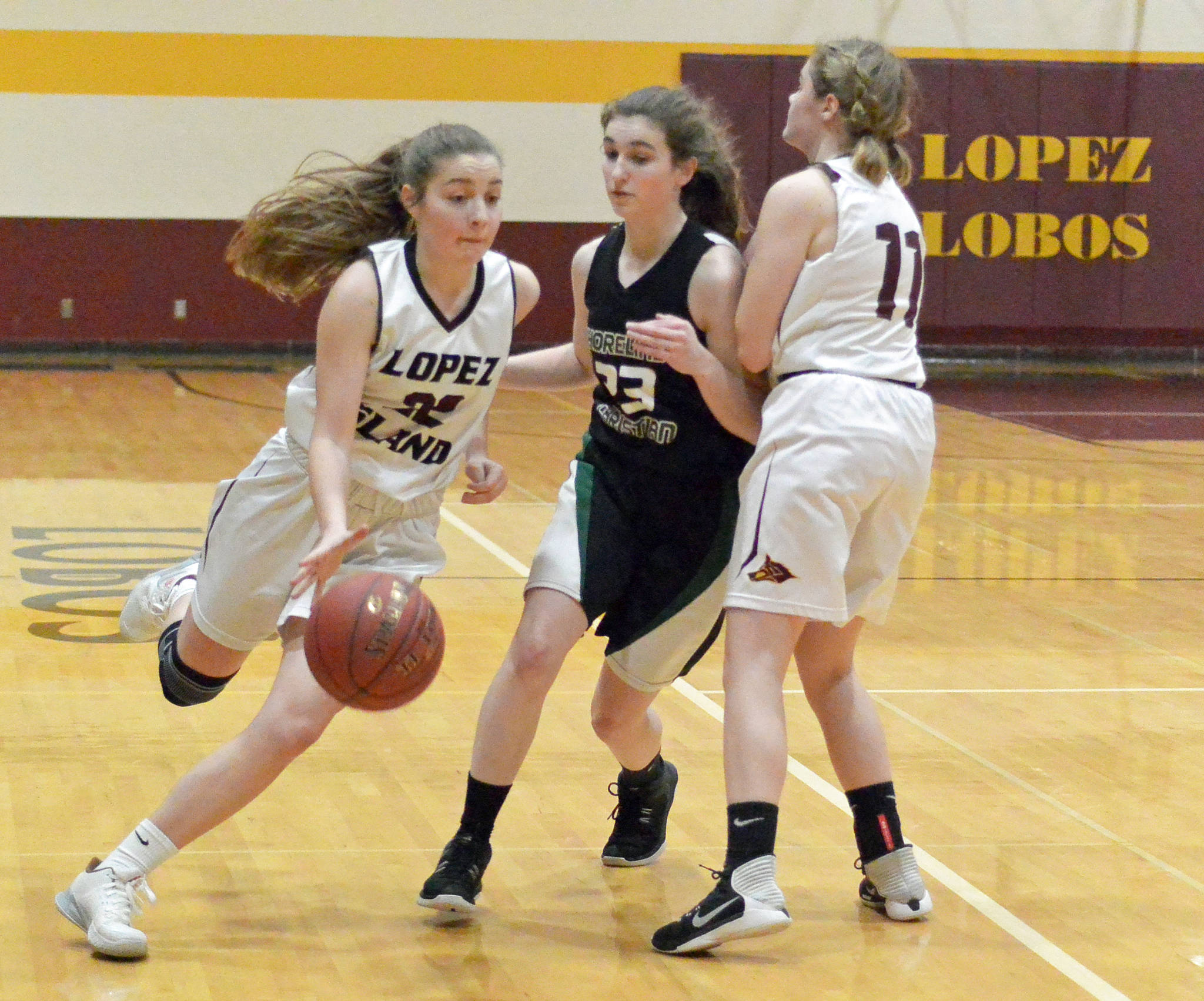 Gene Helfman/Contributed photos                                Top: Avery Conner fights for a rebound against Shoreline Christian as Travis Arnott (42) moves in to assist. Right: Siri Dye drives toward the basket while Shayna Gruenwald (11) blocks a Shoreline defender.