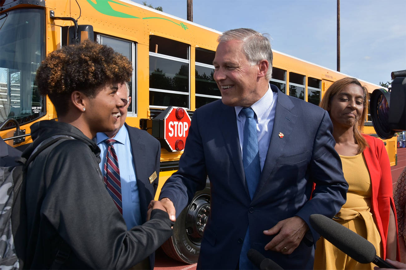 Gov. Jay Inslee speaks to students and education leaders after he rode the electric bus around the stadium track. A full electric charge can power the bus to travel 120 miles. (Office of the Governor photo)