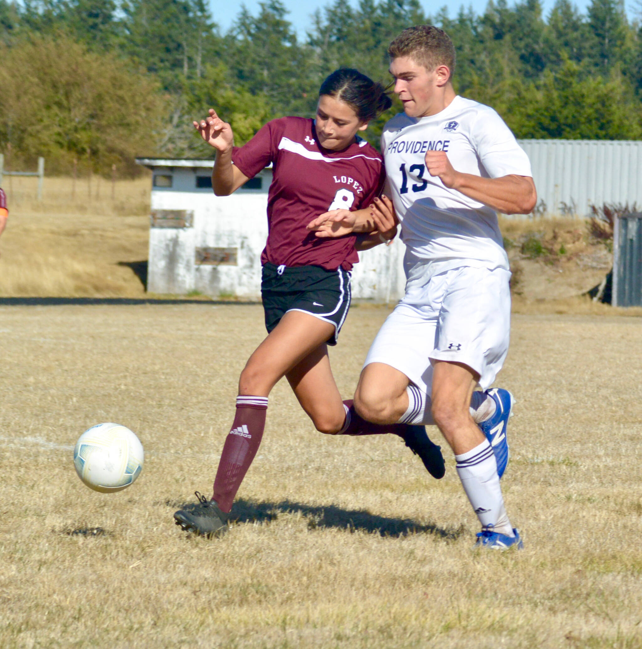 Contributed photo/Lopez midfielder Leah Armstrong fights for the ball against a Providence Christian player in the Lobos’ home opener, Sept. 9.