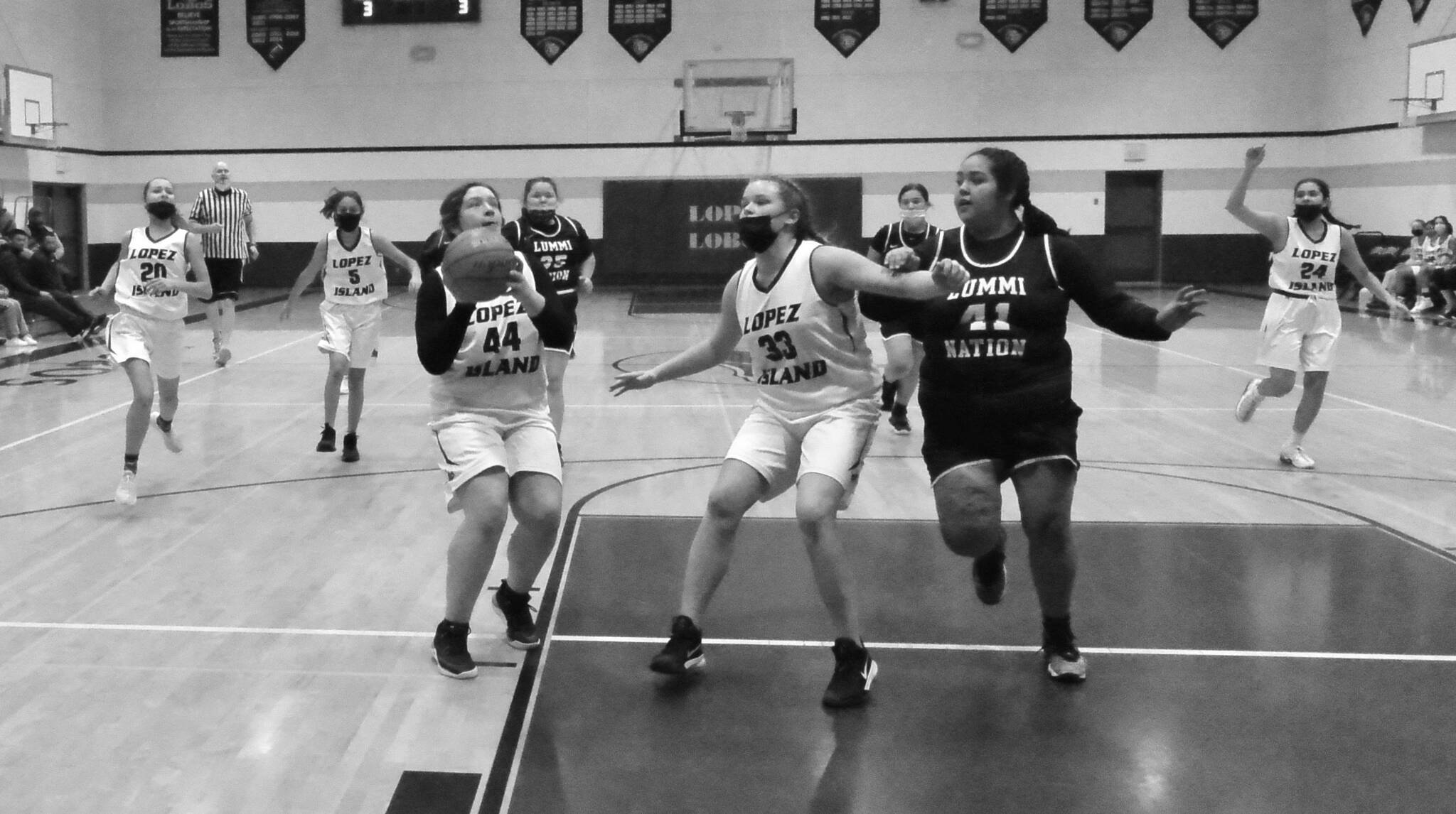Betty Burt (44) prepares to shoot while Danielle Arnott (33) screens for her and Naima Garcia  (20), Michelle Gil (5), and Melissa Valencia (24) move in on a fast break versus Lummi Nation.