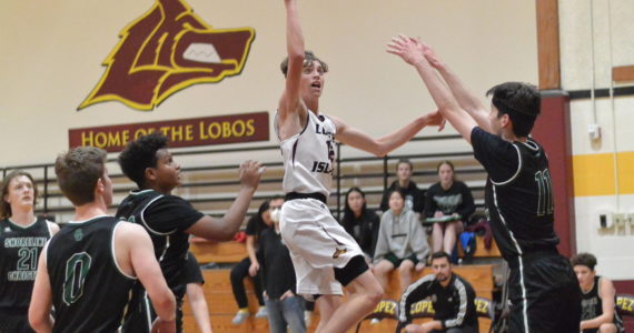 Contributed photo
Ethan Patrick scores despite three Shoreline Christian defenders in the Lobos’ close loss Dec. 6th.