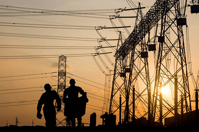 Contributed photo by OPALCO
Silhouette of engineer looking at blueprints in a building site over Blurred substation