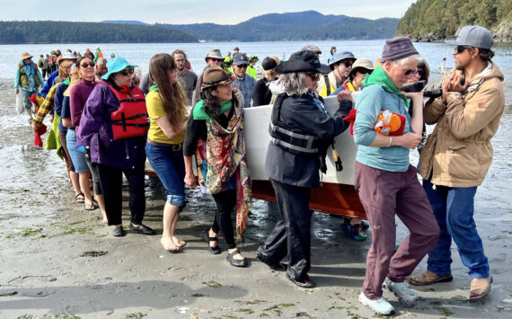 Contributed photo Lopez Friends of Canoe Landings
Volunteers help carry a canoe up the Odlin Park beach during the May 2022 canoe journey.
