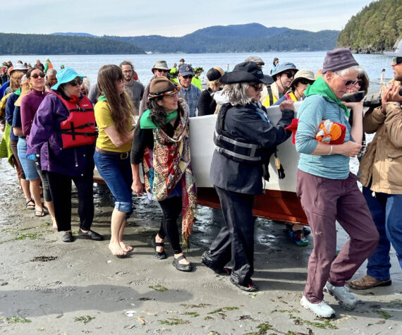 Contributed photo Lopez Friends of Canoe Landings
Volunteers help carry a canoe up the Odlin Park beach during the May 2022 canoe journey.
