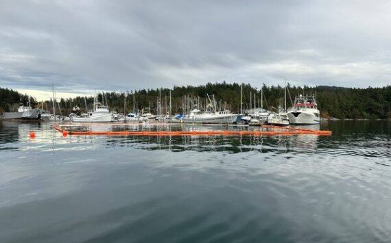 Contributed photo
IOSA staff and volunteers lay out a boom around the sunken tug.