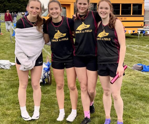 The Lobos girls’ 4x200 meter relay team of (left to right) Iris McClean, Glory Westervelt, Kylie Willemsen and Lily Nichols celebrate their one-second win over Providence Christian in their heat at La Conner, March 19. The Lobos were third overall in a seven-team field, with a personal record time of 1:59.18.