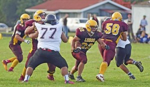 Mike Hobi blocks Tulalip #77 and Erik Jonasson (58) opens the other side of a huge hole to allow Eddie Kramer (22) through on the way to a crucial fourth quarter touchdown against Tulalip.