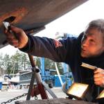 Staff photo/Hayley Day                                Josh Compton repairs the hull of a boat at Albert Jensen and Sons Boat Yard and Marina on San Juan Island. Compton has worked for the shipyard for six months, after moving on island from Everett.