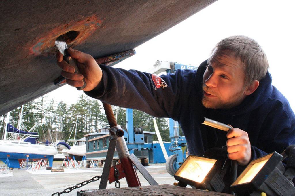 Staff photo/Hayley Day                                Josh Compton repairs the hull of a boat at Albert Jensen and Sons Boat Yard and Marina on San Juan Island. Compton has worked for the shipyard for six months, after moving on island from Everett.
