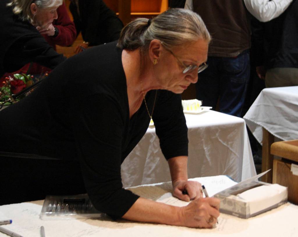 Staff photo/Hayley Day                                Party attendees write greetings to the retiring judge.