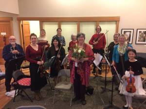 Caption: The Lopez Chamber and Youth Orchestra performed at the Gathering Place at the Hamlet House on ___________. From left to right: Tom Jeffries, trumpet; Juniper Blomberg, violin; Oliver Henderson, violin; Kai Di Bona, violin; Caden Hein, violin and cello; Shannon Wilbur, violin and cello; David Johnson, viola and violin; Julia Mira, violin; Rebecca Berge, violin; Monya Hein, violin; and Celia Rosenberger, director and first violin (center, with flowers).