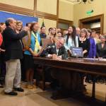 Gov. Jay Inslee signs one of five crucial orca recovery bills on Wednesday that protect the safety and livelihood of the Southern resident orca. (Office of the Governor photo)