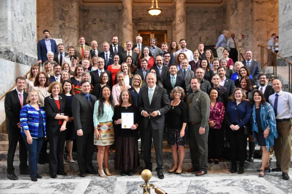Supporters of the orca recovery bills stand for a photo after the governor signed the bills and read an orca proclamation. (Office of the Governor photo).