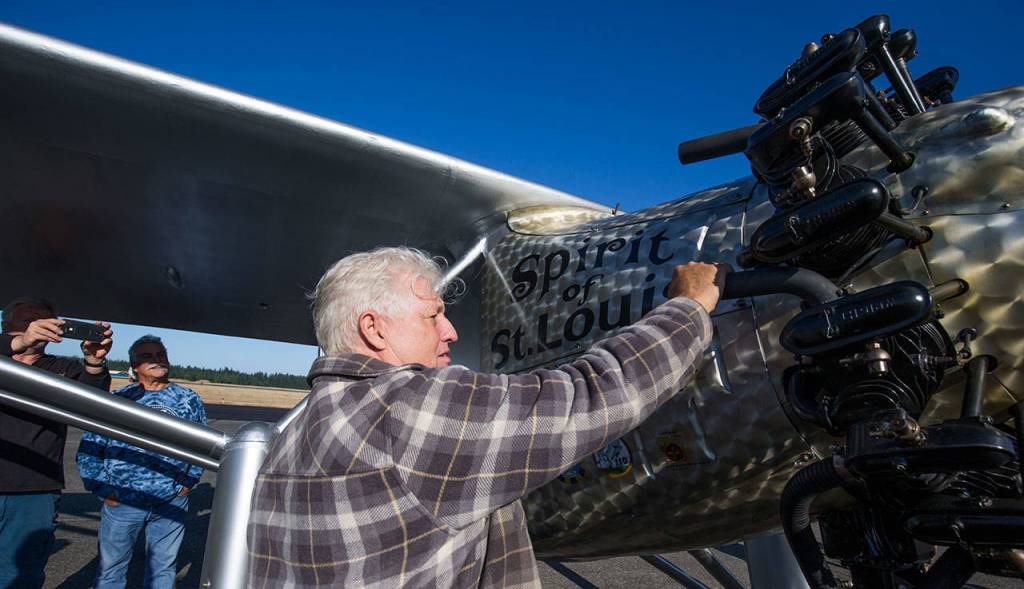 John Normans grabs hold of a cold exhaust pipe after the first flight of his replica airplane, the Spirit of St. Louis, from Arlington Municipal Airport on July 28. A couple cylinders on the engine misfired and were cold at the end of the flight, meaning hell have figure out why they did not work. (Andy Bronson / The Herald)