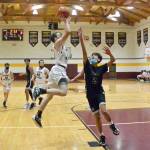 Malachi Cary goes in for a lay-up on a fast break while Ethan Patrick (12), Travis Arnott (42), and Josh Kramer (22) come down the court against Lummi Nation.