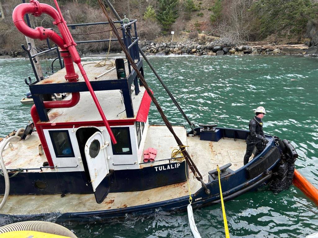 Contributed photo.
The partially submerged Tugboat Tulalip is suspended alongside a response vessel near the Lopez ferry terminal in preparation for removal.