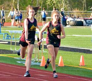 Contributed photo.
Anna Fuller takes the baton from Maya Briggs to anchor the 4 x 400 m relay. The team of Fuller, Briggs, Ruby McClean, and Lily Nicholas earned a slot at the District Finals in Coupeville.