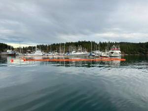 Contributed photo
IOSA staff and volunteers lay out a boom around the sunken tug.