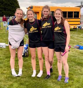 The Lobos girls 4x200 meter relay team of (left to right) Iris McClean, Glory Westervelt, Kylie Willemsen and Lily Nichols celebrate their one-second win over Providence Christian in their heat at La Conner, March 19. The Lobos were third overall in a seven-team field, with a personal record time of 1:59.18.