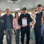 Capt. John McMillian (center) with Sheridan Ferguson and her father (left center), Brent Campbell and family (right), and Margaret Pommert with U.S. Sailing Foundation (far left).
